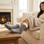 Frau sitzt auf dem Sofa mit Kuschelsocken