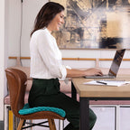 Frau nutzt das Dreamolino Soft Sitter Sitzkissen beim arbeiten